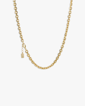 Gold chain necklace on a light grey background