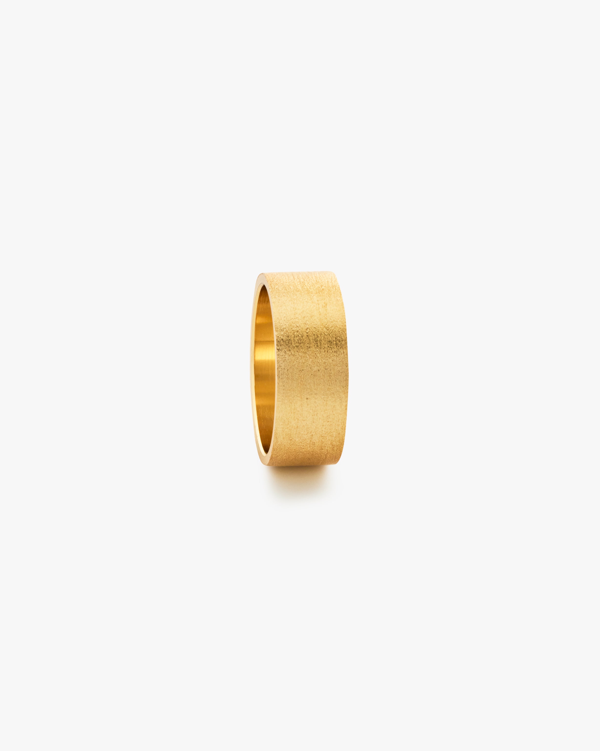 Gold ring on a light grey background