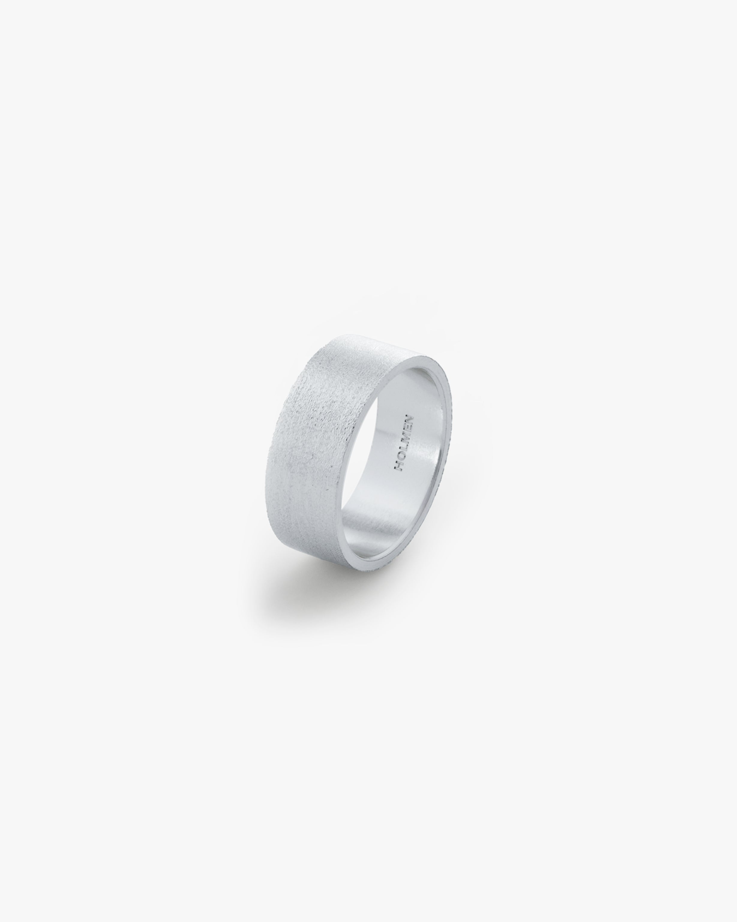 Silver ring with 'HOLMEN' engraving on a light grey background