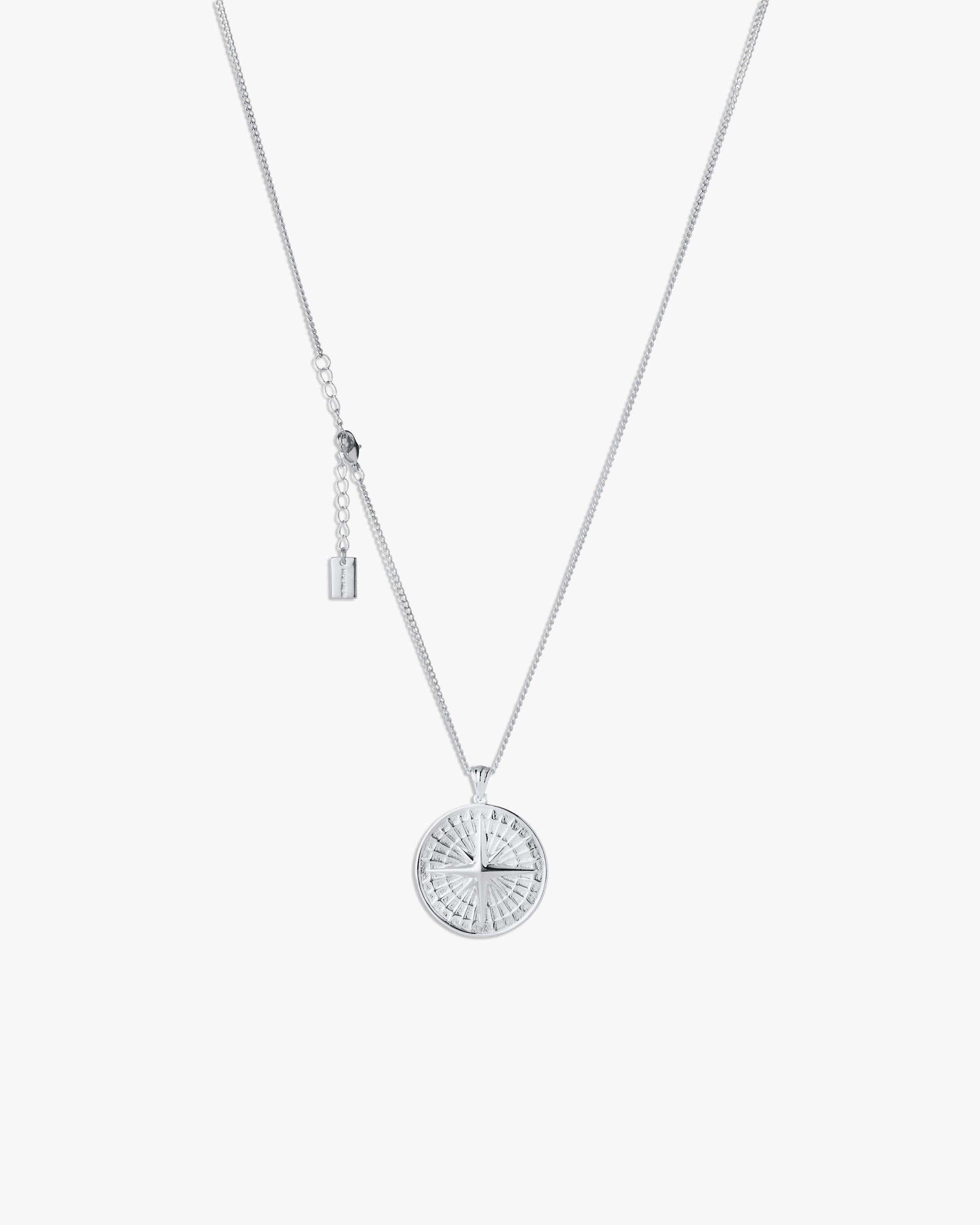 Silver compass necklace with light grey  background