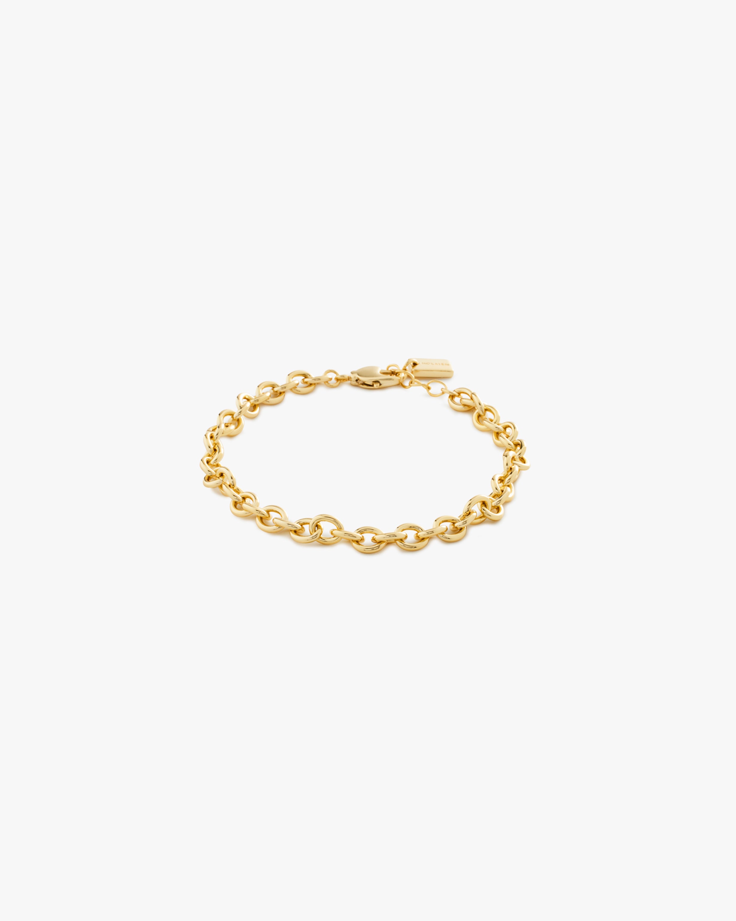 Gold chain bracelet on a light grey background