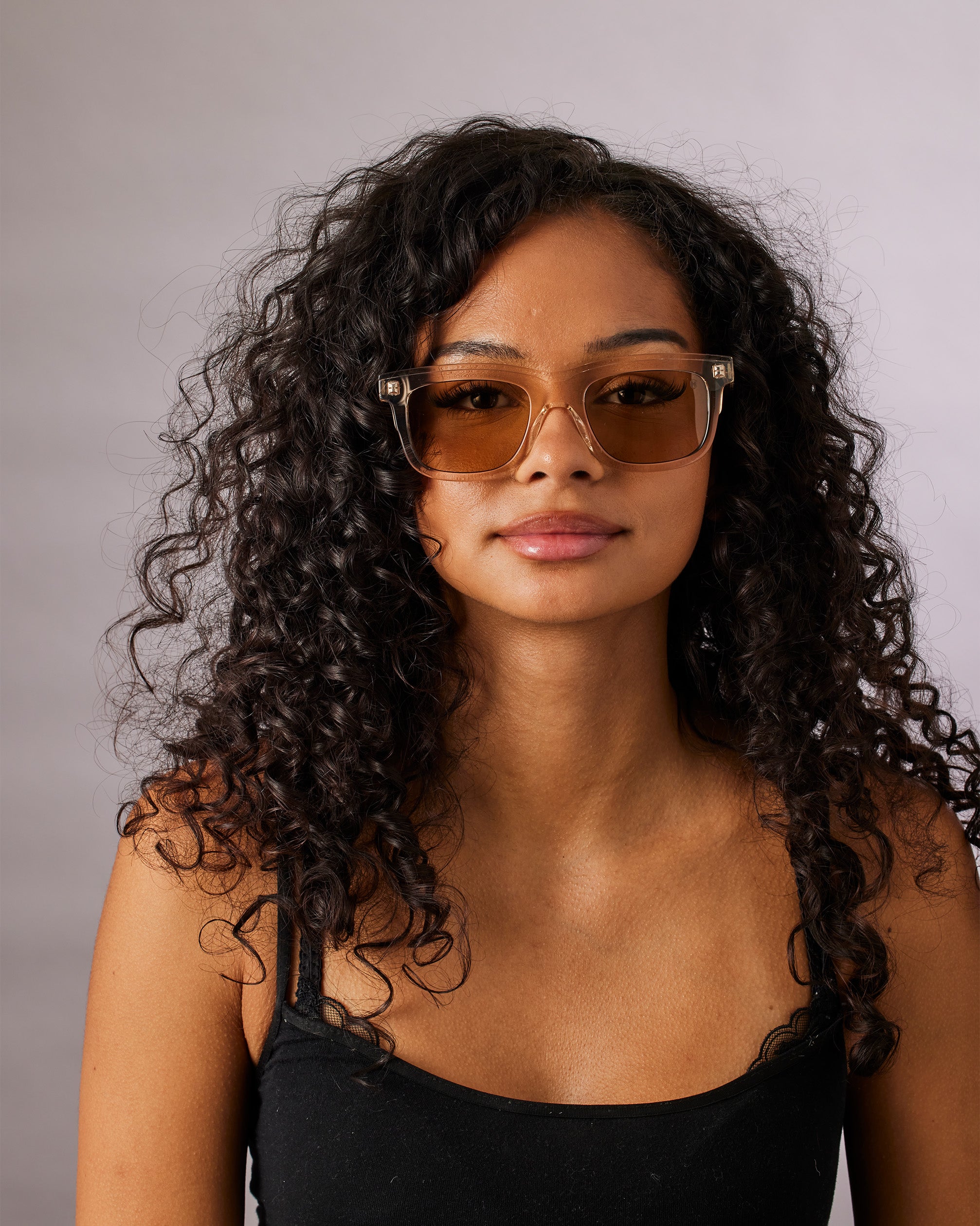 Woman wearing sunglasses with a neutral background