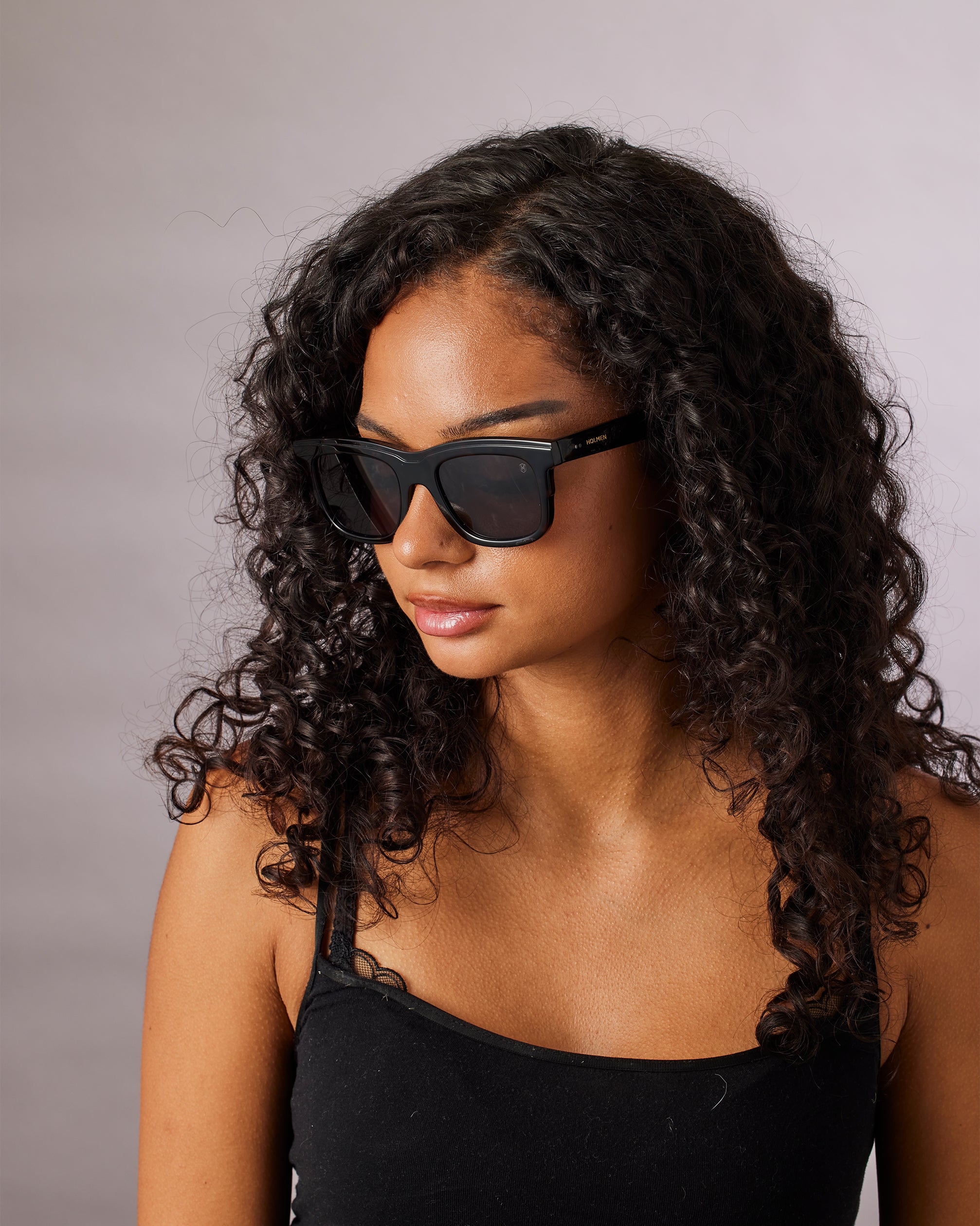Woman wearing black sunglasses with a neutral background