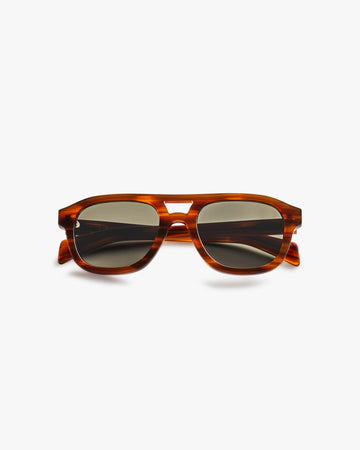 Brown sunglasses with a tortoiseshell frame on a light grey background