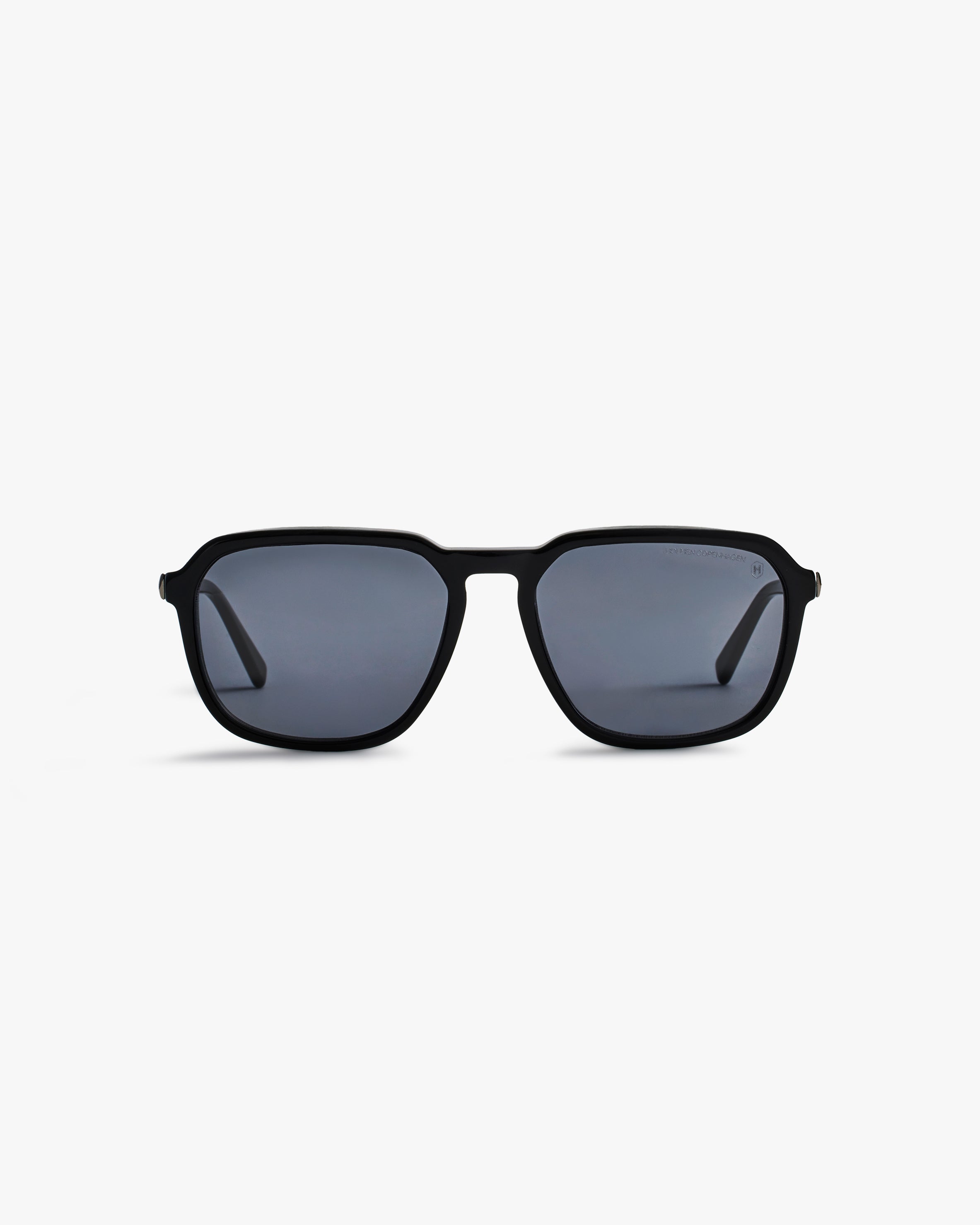 Black sunglasses with dark lenses on a light grey background