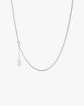 Silver necklace on a light grey background