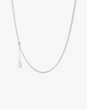 Silver necklace on a light grey background