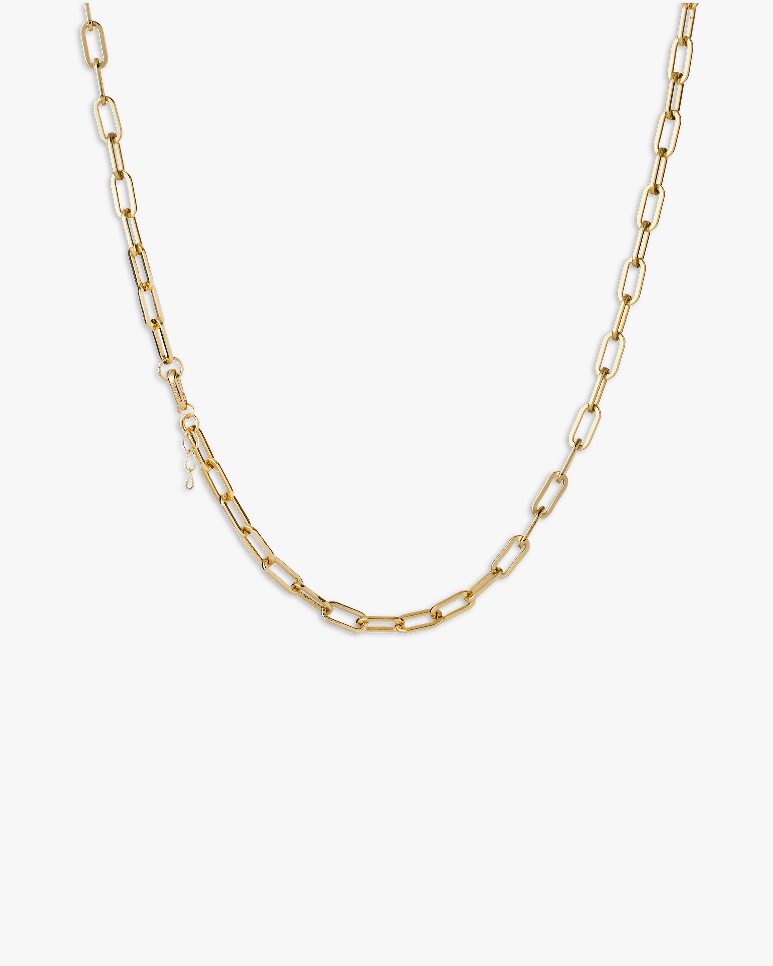 Gold chain necklace on a light grey background