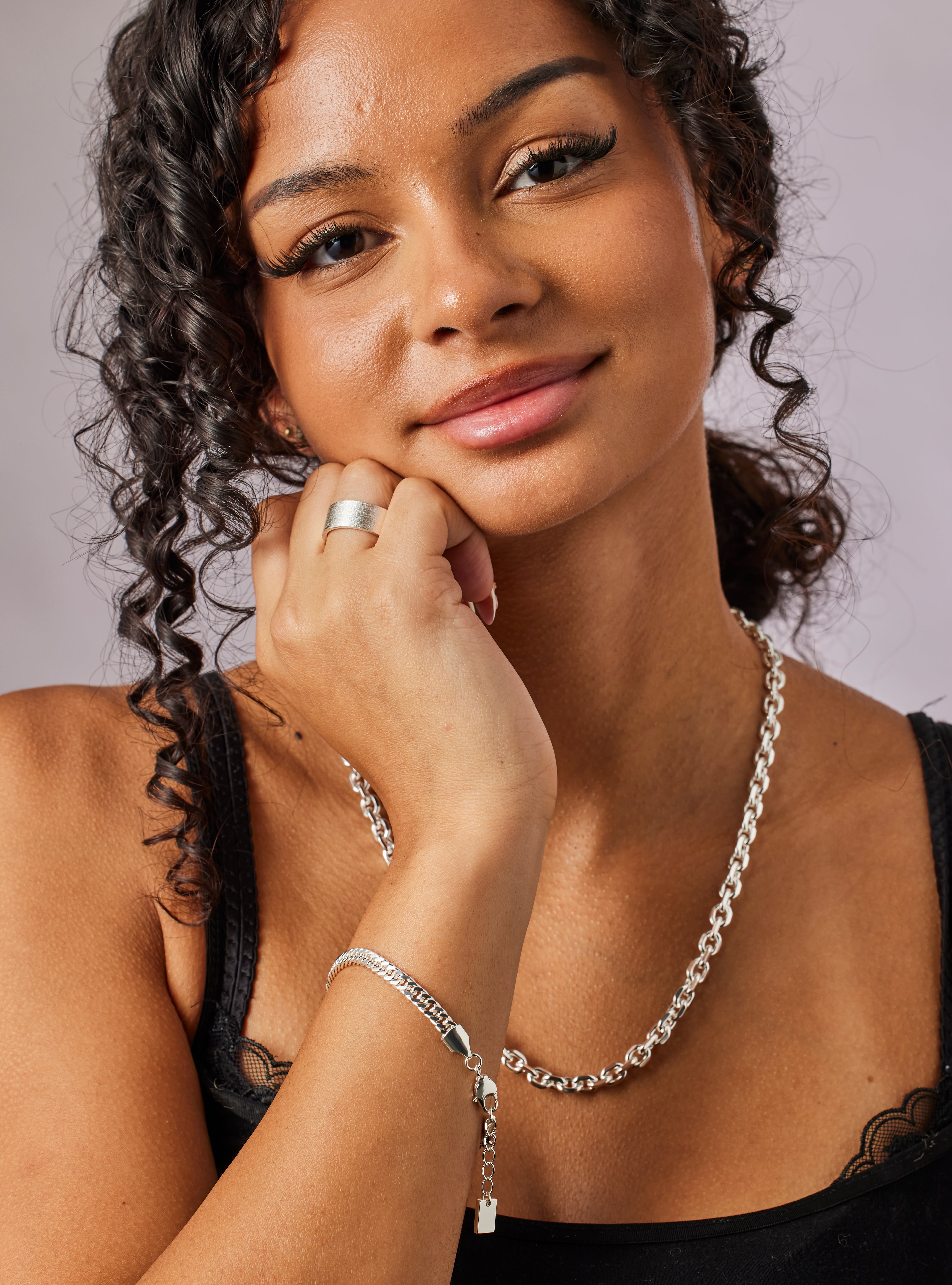 Woman wearing silver jewelry with a neutral background